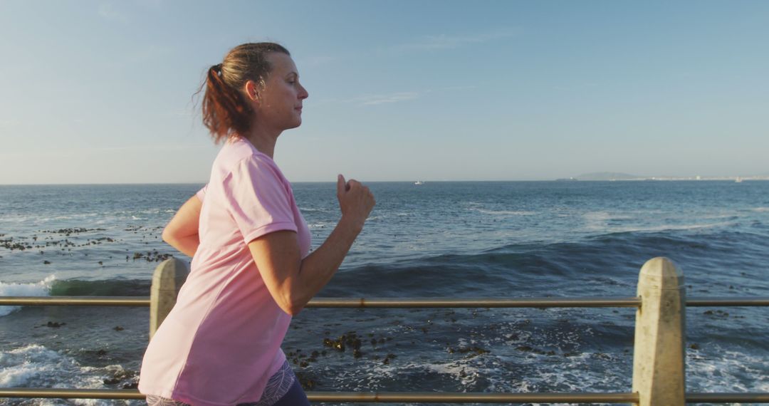 Woman Jogging Along Oceanfront Promenade - Free Images, Stock Photos and Pictures on Pikwizard.com