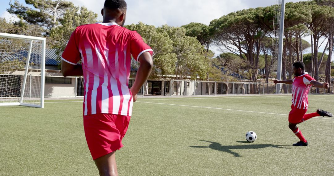 Soccer Players Practicing Kicking Techniques on Field