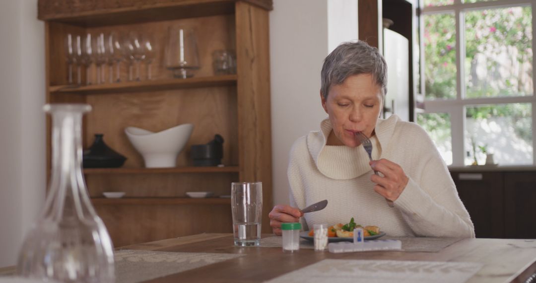 Elderly Woman Eating Healthy Meal at Modern Dining Table - Free Images, Stock Photos and Pictures on Pikwizard.com