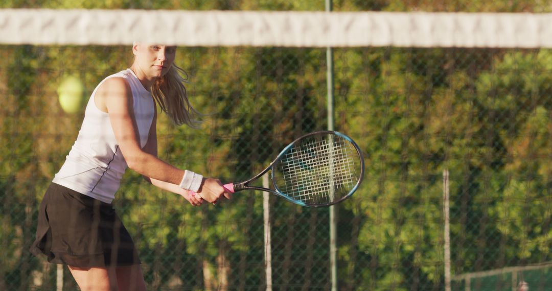 Female Tennis Player Ready to Hit Ball with Racket Outdoors - Free Images, Stock Photos and Pictures on Pikwizard.com