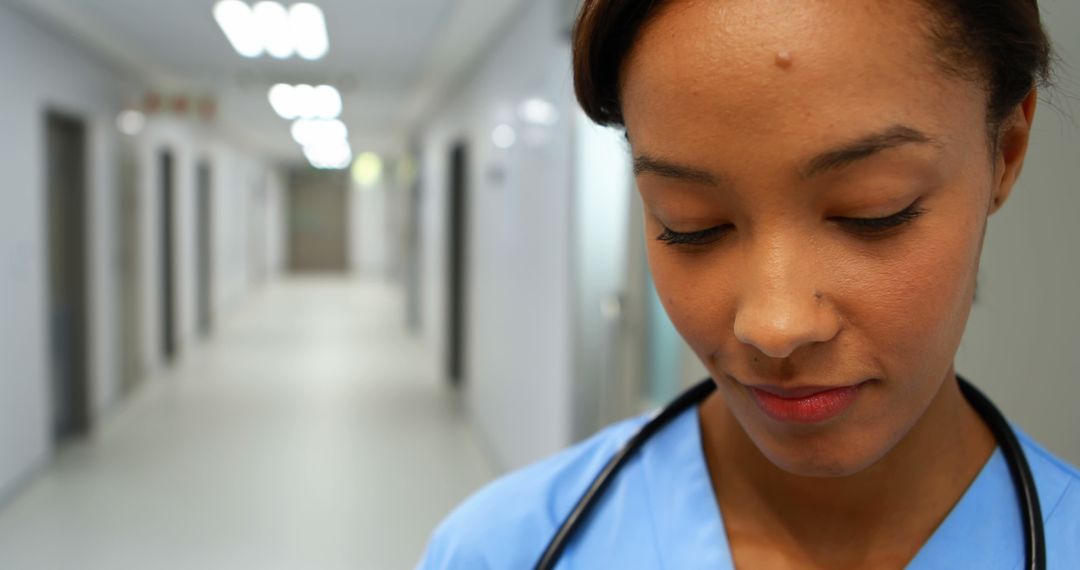 Young African American Female Nurse in Medical Uniform Smiling in Hospital Corridor - Free Images, Stock Photos and Pictures on Pikwizard.com