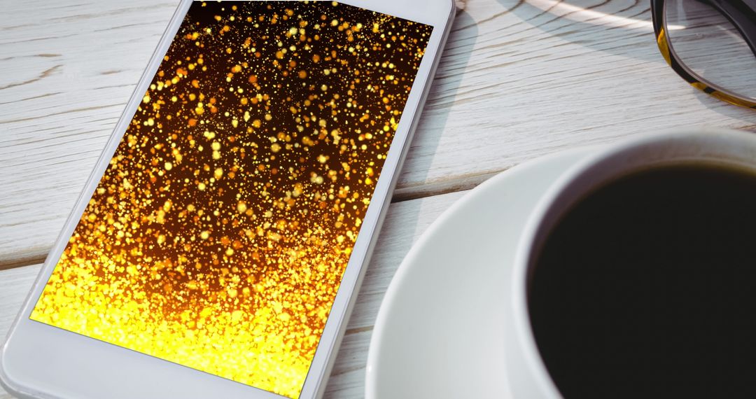 Smartphone Displaying Golden Light Trails with Coffee Cup