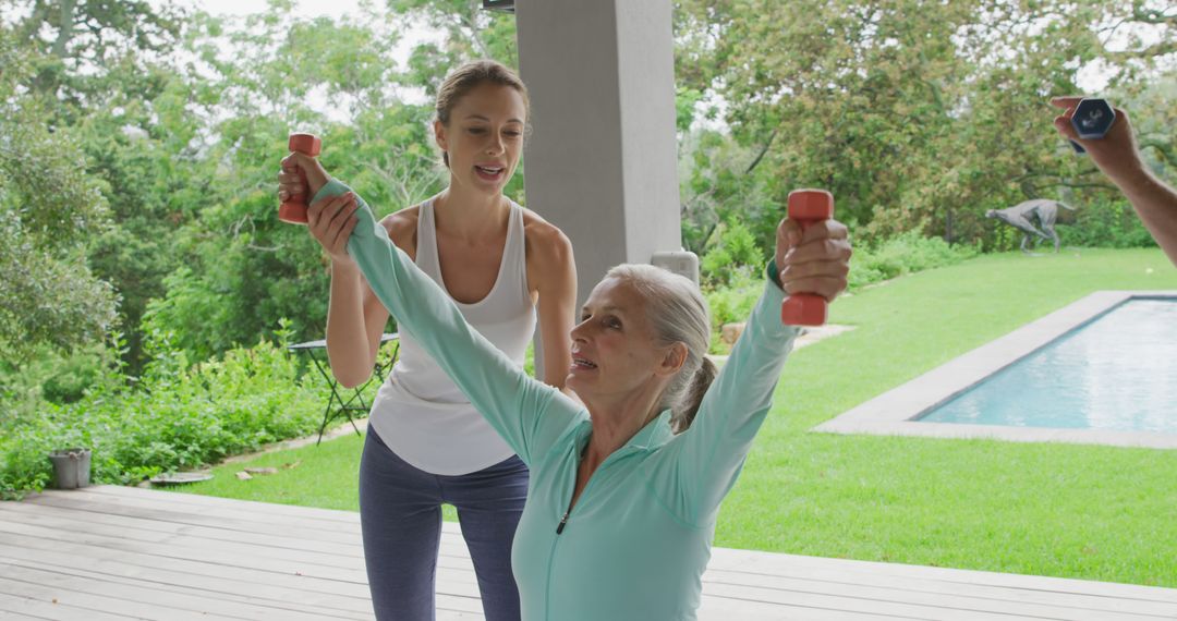 Personal trainer assisting senior woman with dumbbell exercise outdoors - Free Images, Stock Photos and Pictures on Pikwizard.com