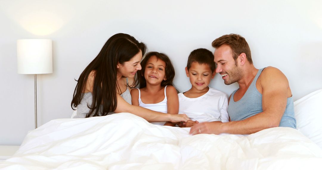 Happy Family Relaxing in Bed Together in the Morning - Free Images, Stock Photos and Pictures on Pikwizard.com