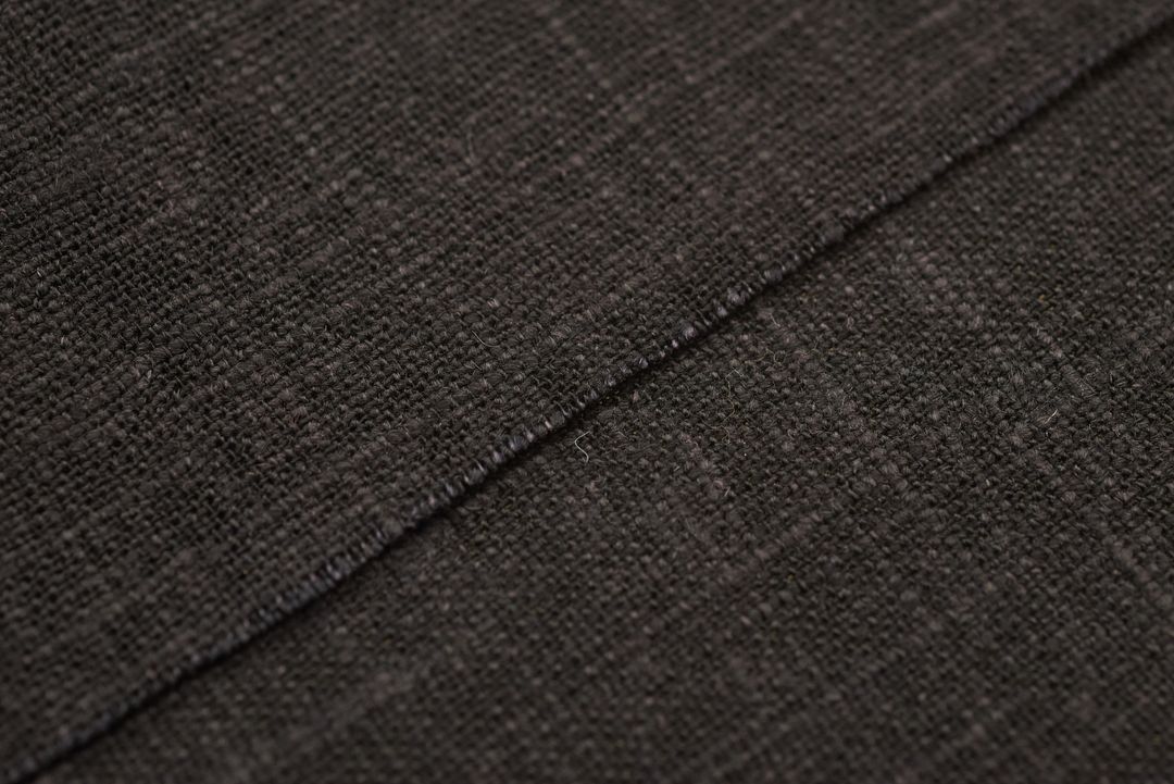 Black Linen Fabric Close-Up Showing Diagonal Seam, Woven Texture and Subtle Fibers
