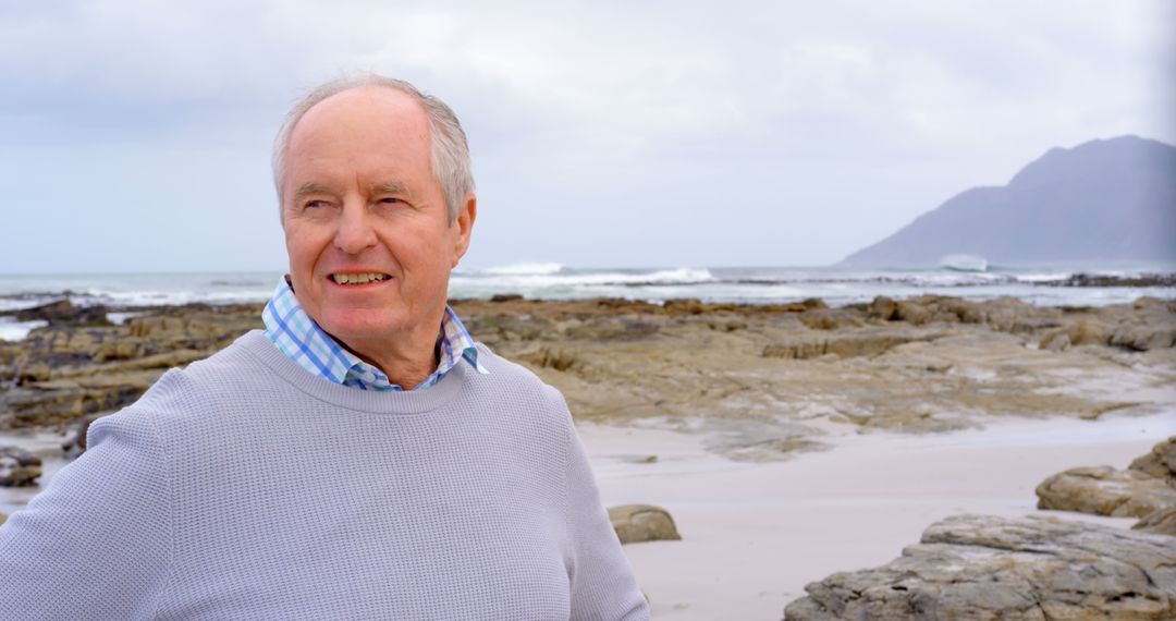 Senior Man Smiling on Rocky Beach - Free Images, Stock Photos and Pictures on Pikwizard.com