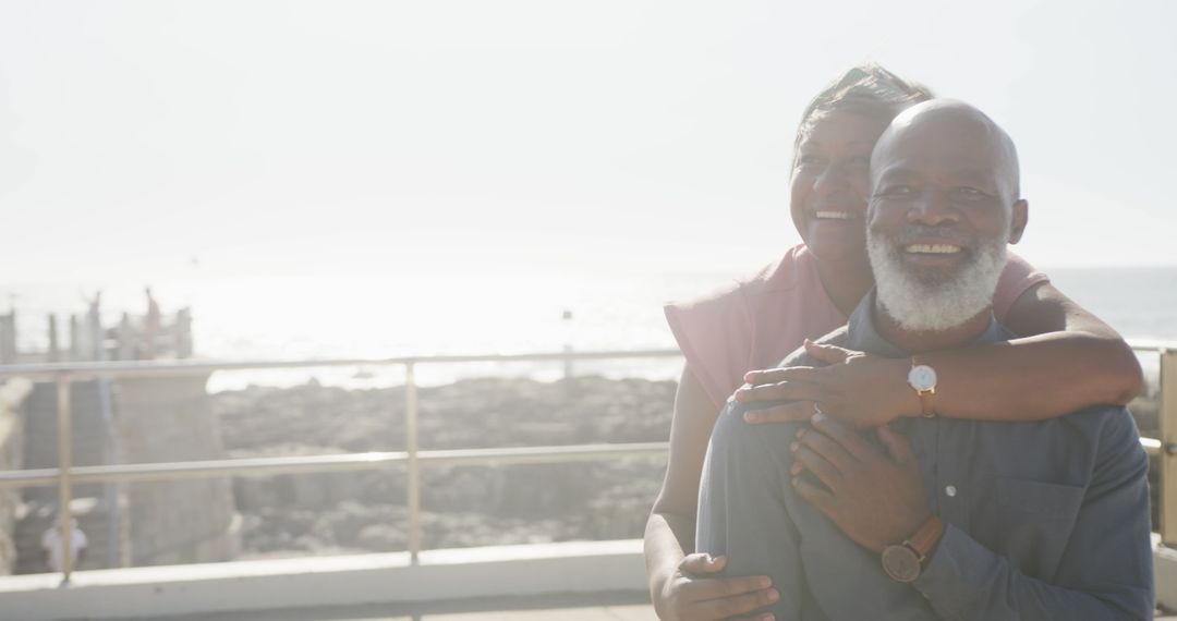 Smiling Senior Couple Embracing Near Beachfront