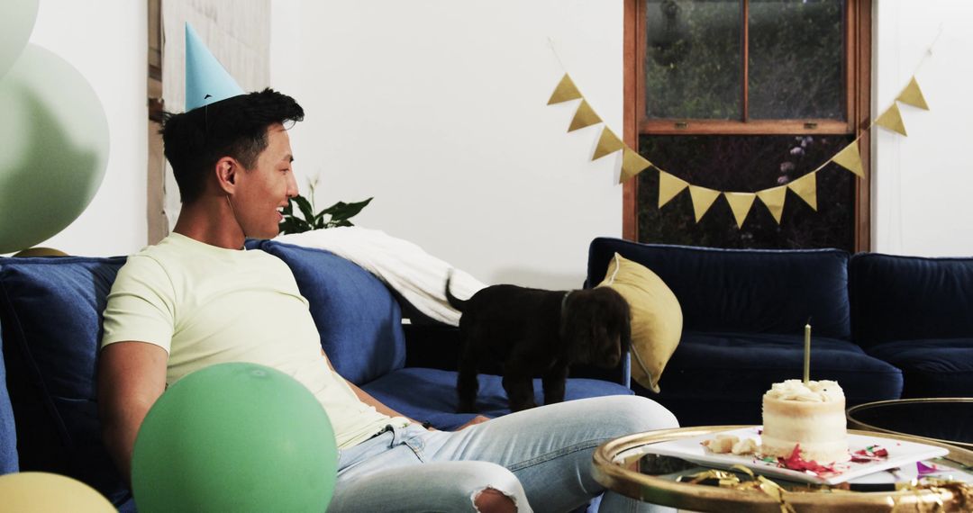 Young Man Celebrating Birthday with Puppy at Home Party