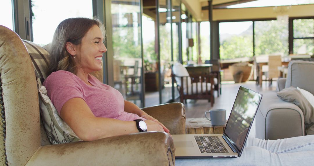Pregnant Woman Relaxing and Laughing While Using Laptop
