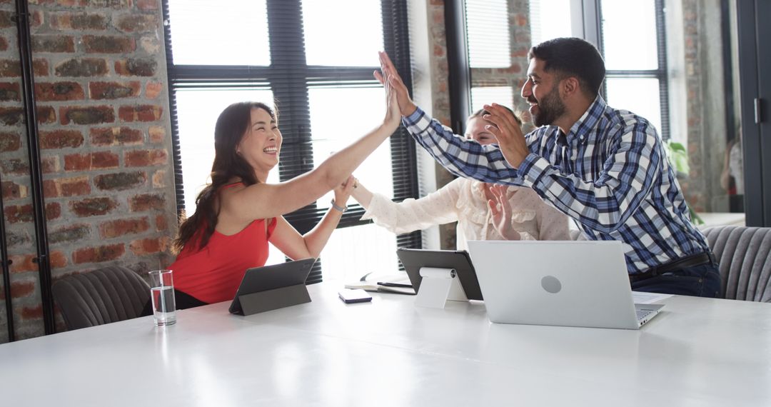 Diverse Team Celebrating Success at Workplace with High Five