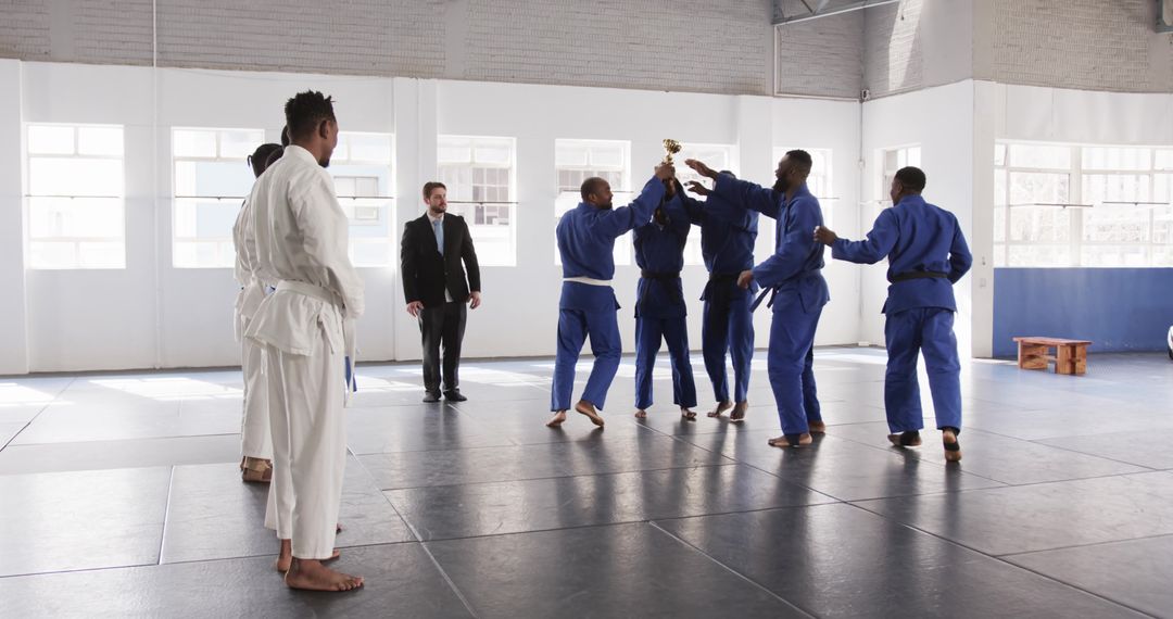 Diverse Judo Team Celebrates Victory with Trophy in Dojo