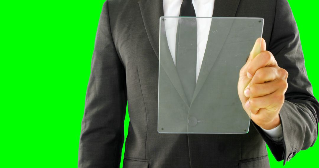 Businessman Holding Transparent Digital Screen on Bright Green Background - Free Images, Stock Photos and Pictures on Pikwizard.com