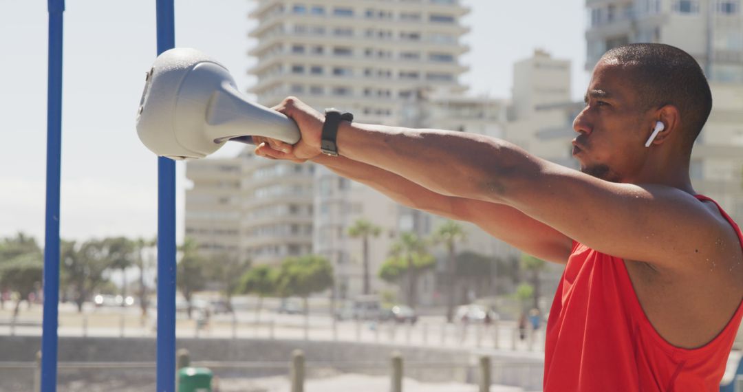 Focused Man Exercising with Kettlebell at Beachfront - Free Images, Stock Photos and Pictures on Pikwizard.com