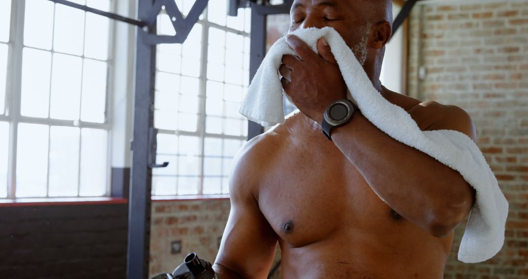 Male athlete wiping sweat with towel in gym - Free Images, Stock Photos and Pictures on Pikwizard.com