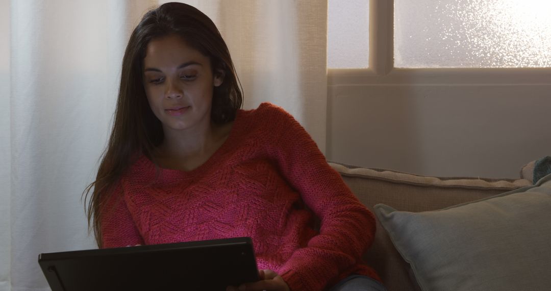 Woman in Cozy Living Room Browsing on Tablet - Free Images, Stock Photos and Pictures on Pikwizard.com