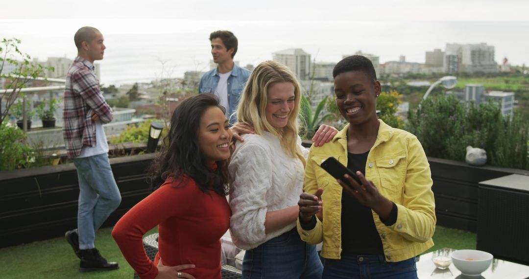 Diverse Friends Sharing Moment on Rooftop with Smartphone - Free Images, Stock Photos and Pictures on Pikwizard.com