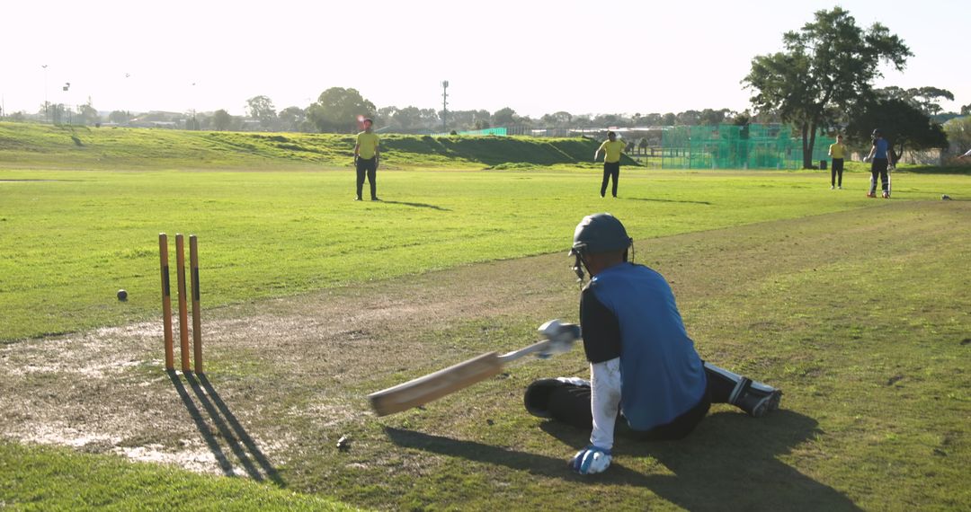 Cricket Player Sitting on Pitch After Unfortunate Dismissal Scene