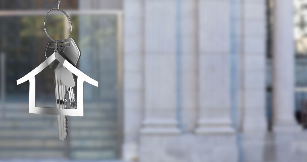 Silver House Keys Hanging Against Building Background