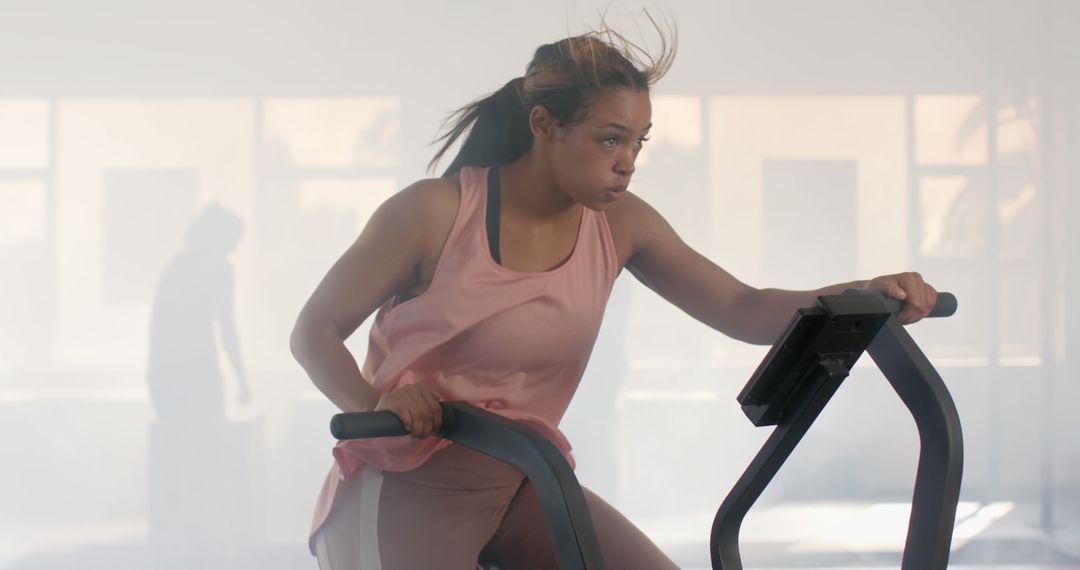 Determined Woman Exercising on Stationary Bike in Modern Gym - Free Images, Stock Photos and Pictures on Pikwizard.com