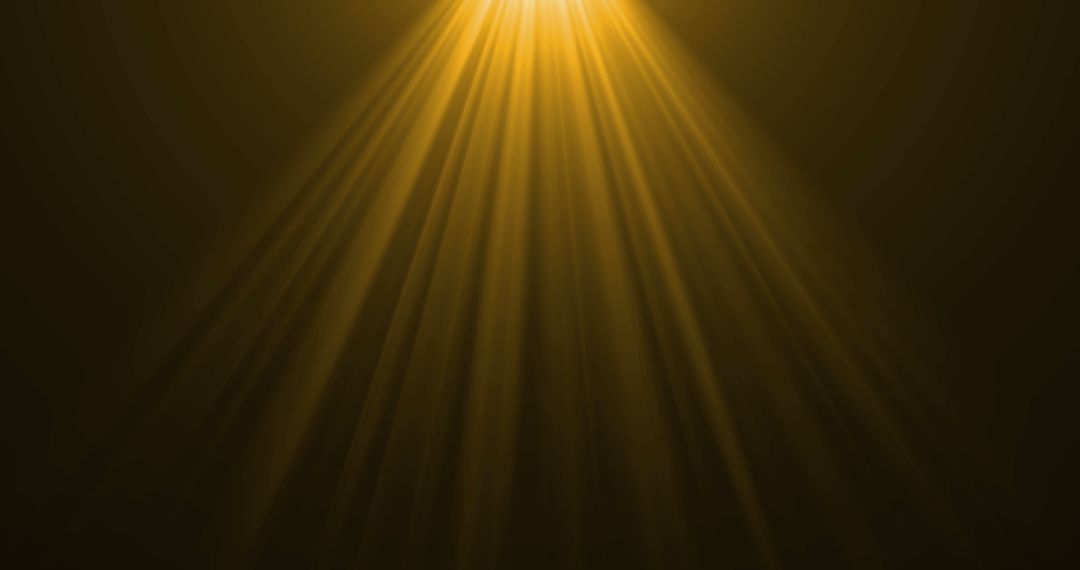 Golden Light Rays Shining Over Dark Background