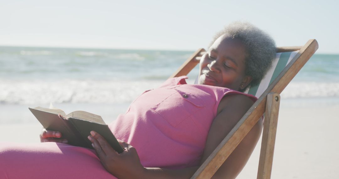 Senior Woman Relaxing on Beach Chair Reading Book at Seaside - Free Images, Stock Photos and Pictures on Pikwizard.com