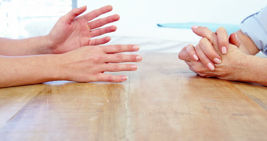 Close-up of Hands Discussing Together Sitting at Table - Free Images, Stock Photos and Pictures on Pikwizard.com