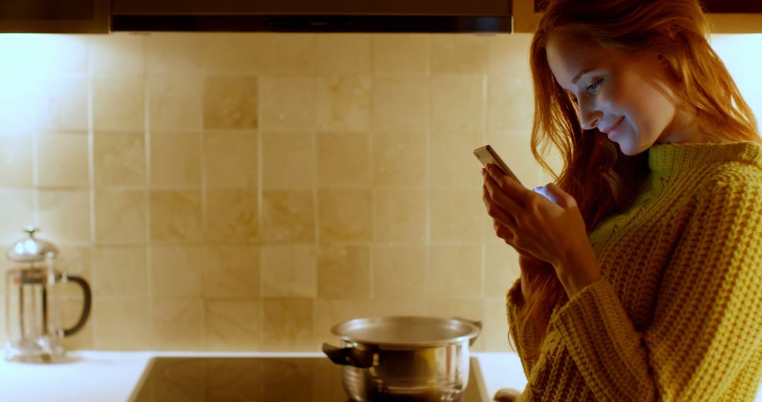 Young Redhead Woman Cooking at Home and Using Smartphone - Free Images, Stock Photos and Pictures on Pikwizard.com