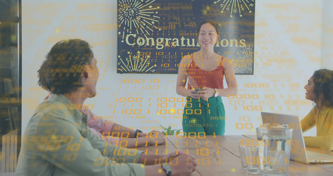 Young woman presenting to team in modern office celebrating achievement and teamwork