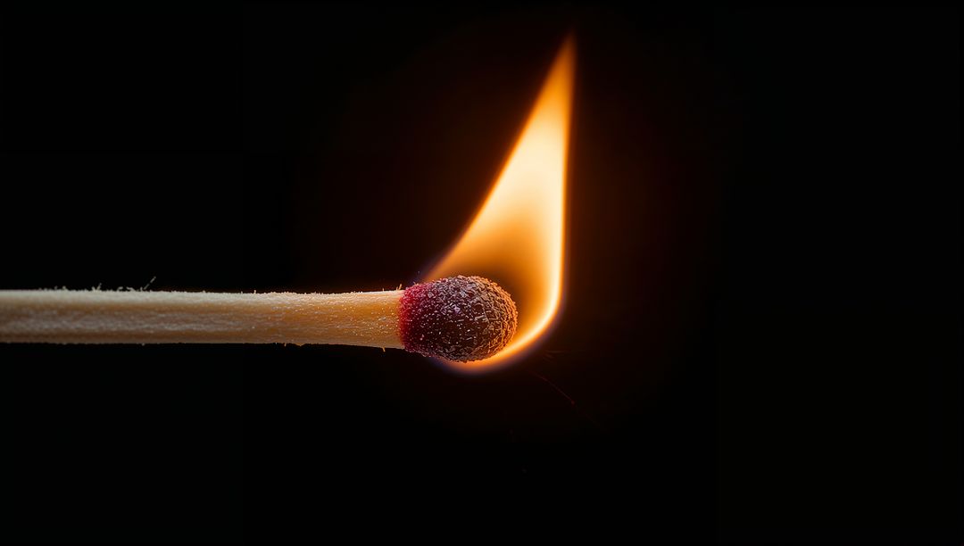Single Burning Match Close-Up with Bright Flame and Glowing Ember on Black Background