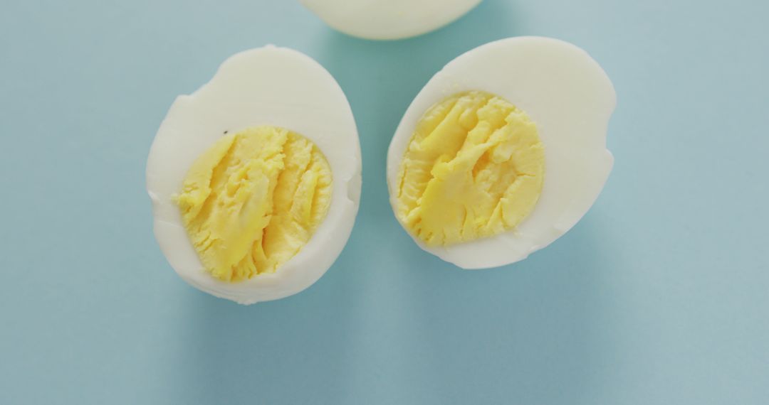 Image of overhead view of three egg halves on blue background - Free Images, Stock Photos and Pictures on Pikwizard.com