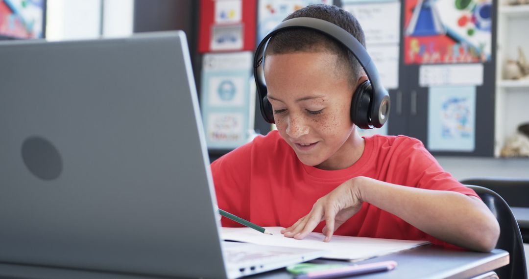 Young Boy with Freckles Enjoys Learning with Laptop and Headphones