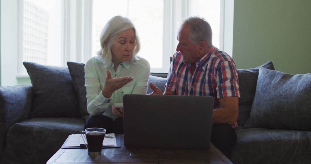 Senior Couple Discussing Finances at Home Using Laptop