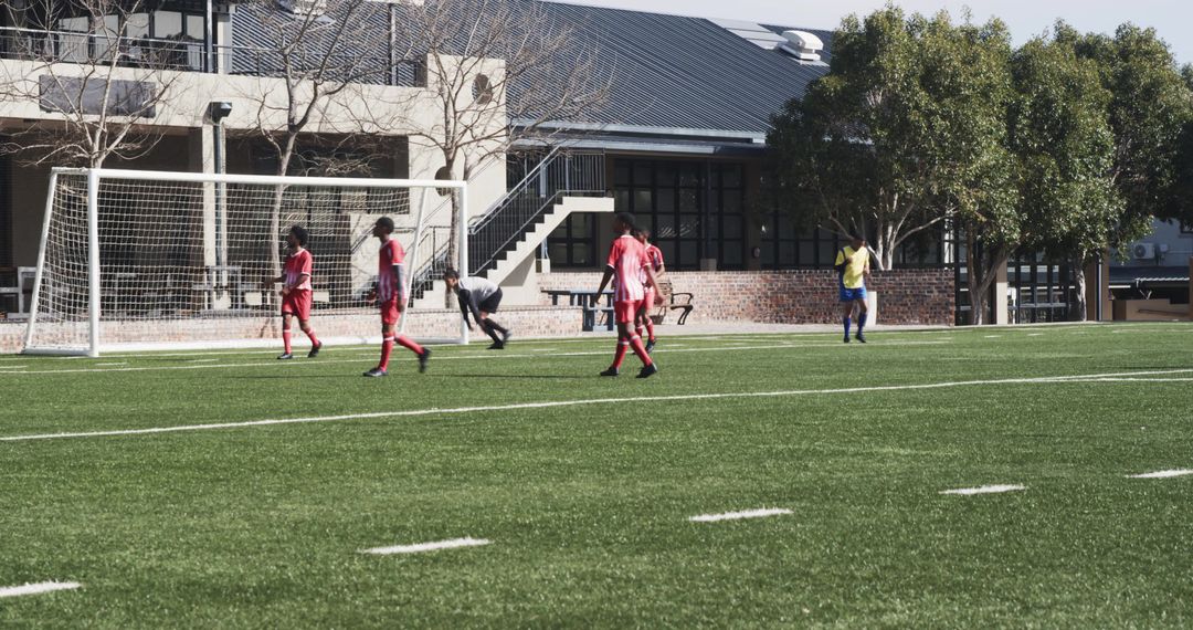Soccer Players Competing in Outdoor Game on Green Field