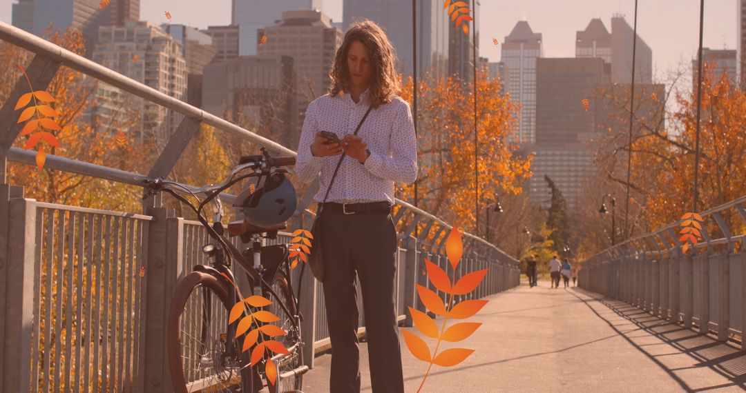 Young Man Using Smartphone on City Bridge with Autumn Leaves