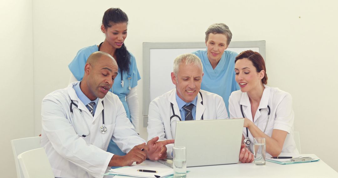 Diverse Medical Team Discussing Patient Records on Laptop - Free Images, Stock Photos and Pictures on Pikwizard.com