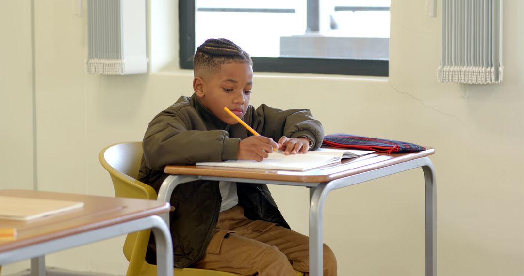 Focused Boy Learning at School Desk in Classroom