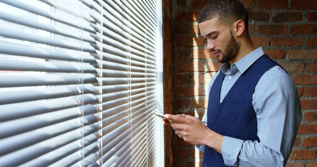 Business Professional Using Smartphone by Window Blinds - Free Images, Stock Photos and Pictures on Pikwizard.com