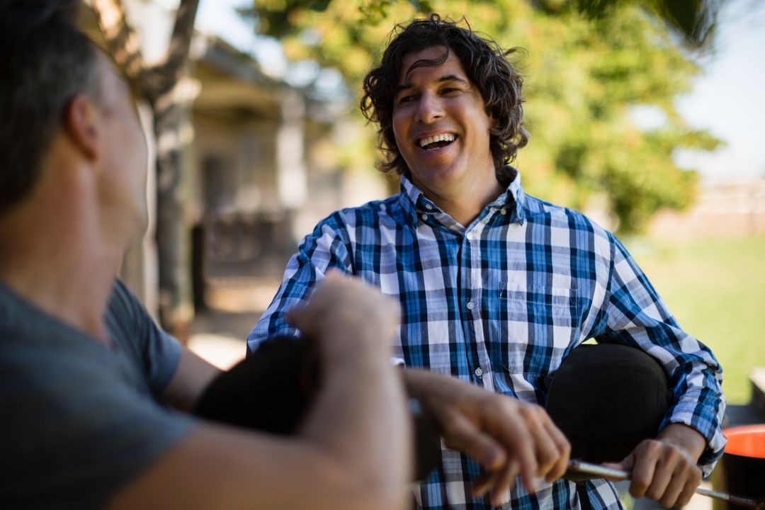 Two Male Friends Laughing Outdoors on Sunny Day - Free Images, Stock Photos and Pictures on Pikwizard.com