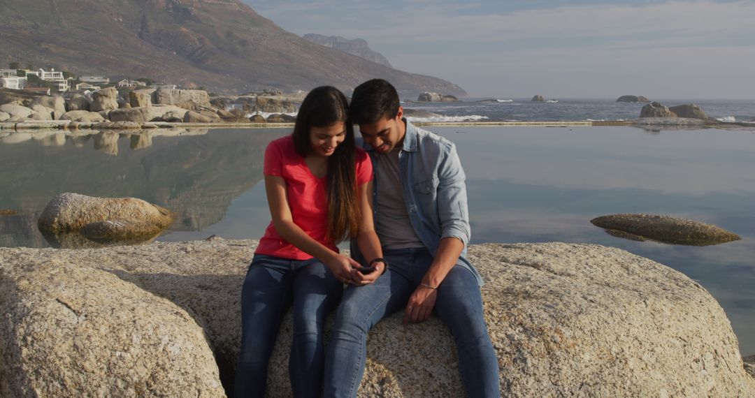Happy Couple Enjoying Beach View and Using Smartphone