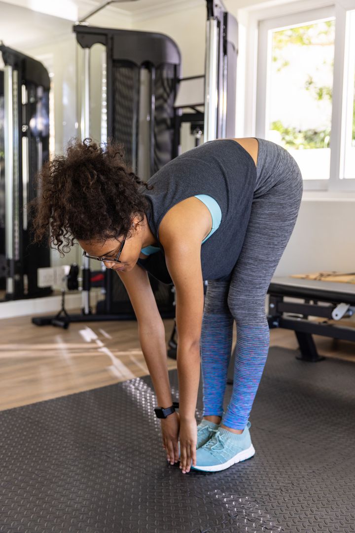 Woman Practicing Forward Bend Exercise on Gym Mat