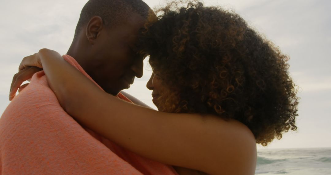 Romantic Couple Embracing Under Blanket on Beach