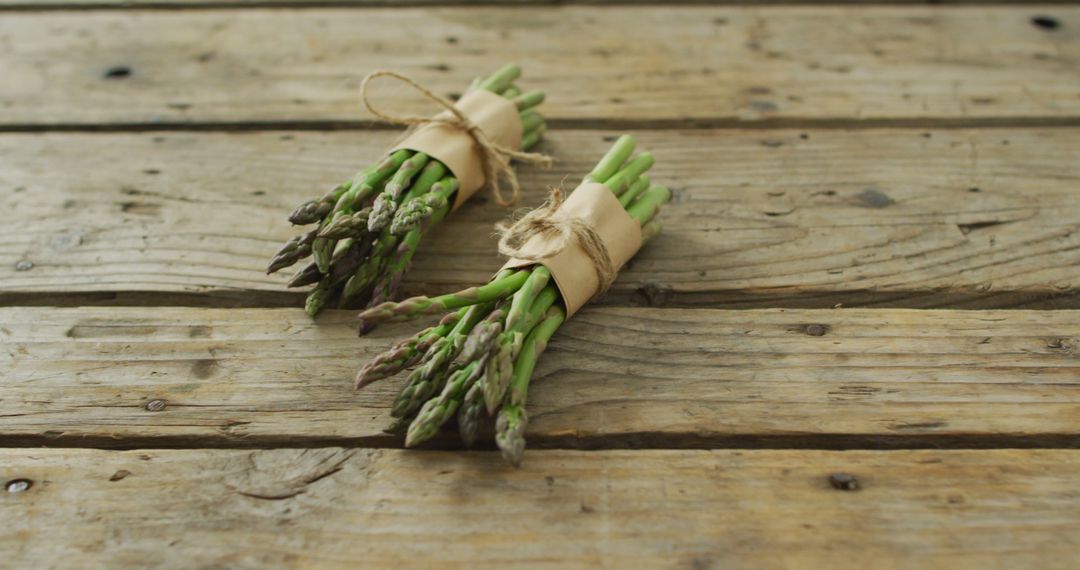 Image of two fresh asparagus bundles on wooden background - Free Images, Stock Photos and Pictures on Pikwizard.com