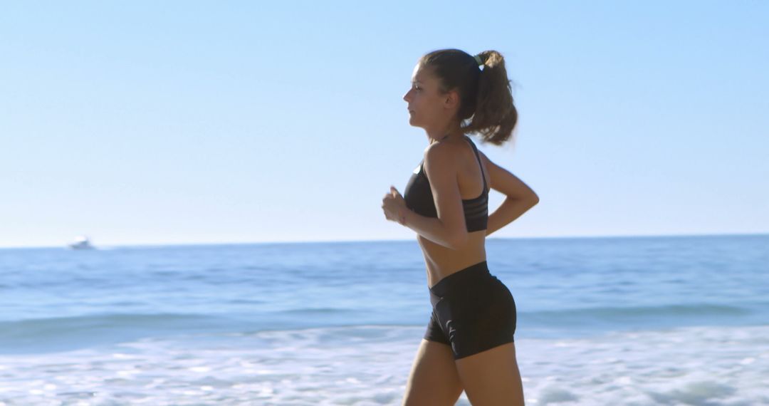 Woman jogging on beach in workout attire - Free Images, Stock Photos and Pictures on Pikwizard.com