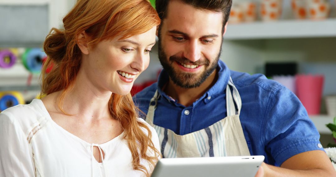 Happy Florist Duo Using Tablet in Flower Shop Setting