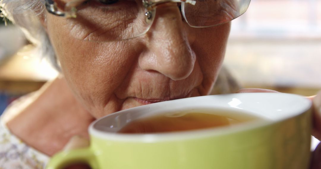 Senior woman sipping hot tea from mug, close-up view - Free Images, Stock Photos and Pictures on Pikwizard.com