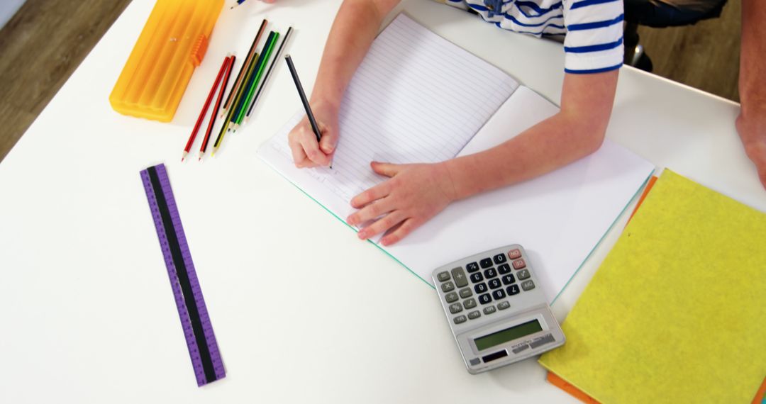 Child Engaged in Homework with School Supplies and Calculator