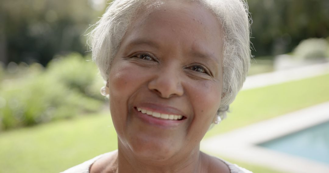 Senior Woman Smiling Outdoors on Sunny Day - Free Images, Stock Photos and Pictures on Pikwizard.com