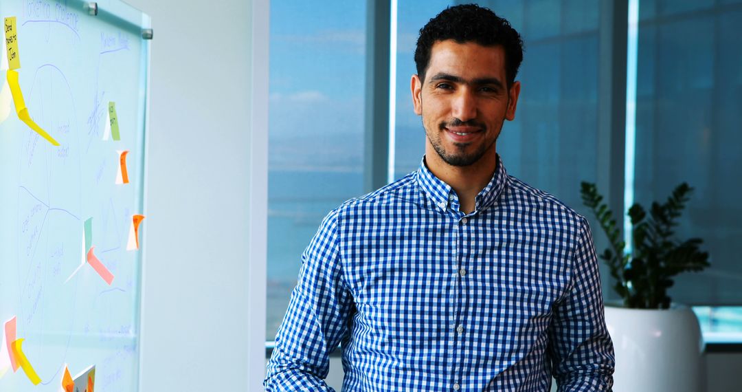 Middle Eastern Businessman Standing in Modern Office with Whiteboard