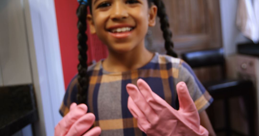 Smiling Girl Wearing Pink Gloves in Kitchen Doing Chores - Free Images, Stock Photos and Pictures on Pikwizard.com