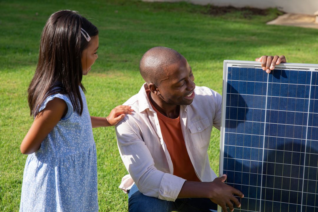 Father and Daughter Exploring Solar Panel in Garden